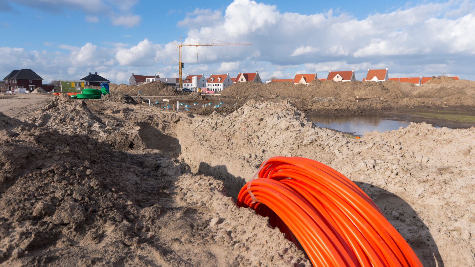 Orange fiber cables in the ground near a subdivision